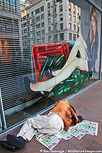 A homeless man sleeps in front of a photo of a glamorous model, San Francisco, California. A homeless man sleeps in front of a photo of a glamorous model, San Francisco, California.